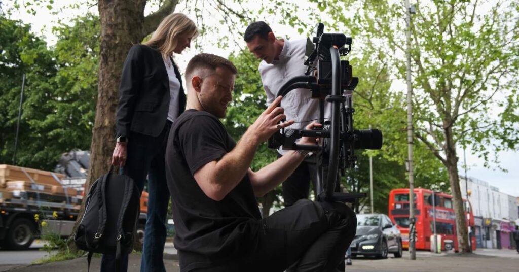 Three people shooting on a film camera in London street