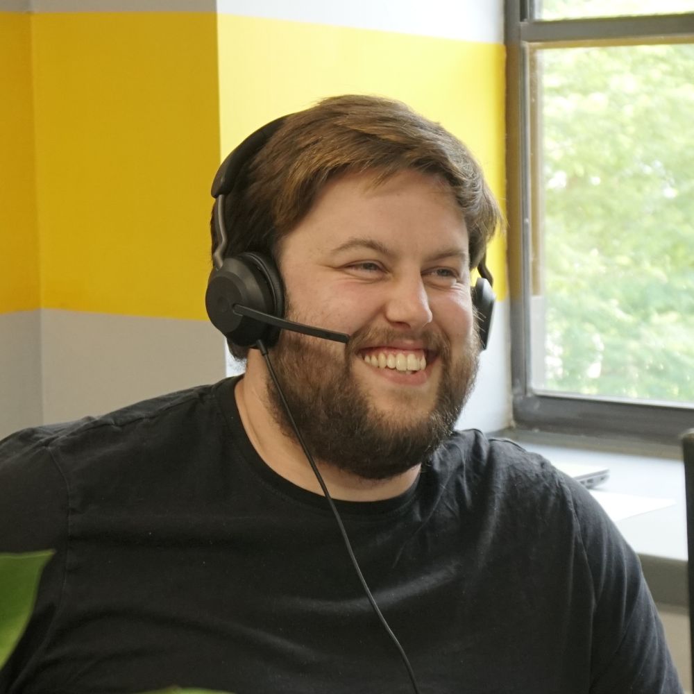 Man in office smiling wearing a headset