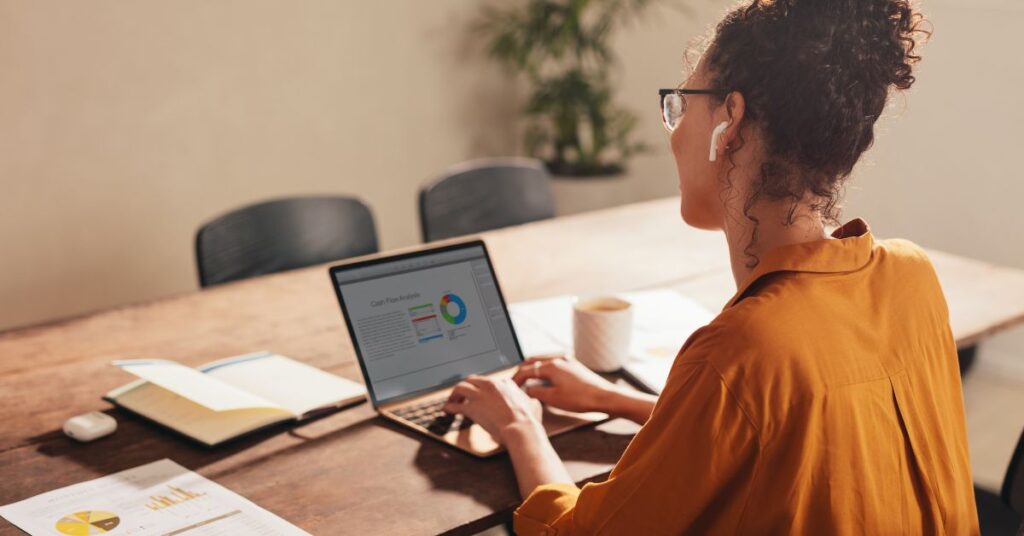 Woman working from home with report on laptop