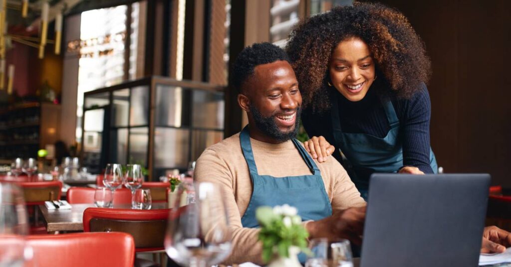 Man and woman on a laptop in a restaurant