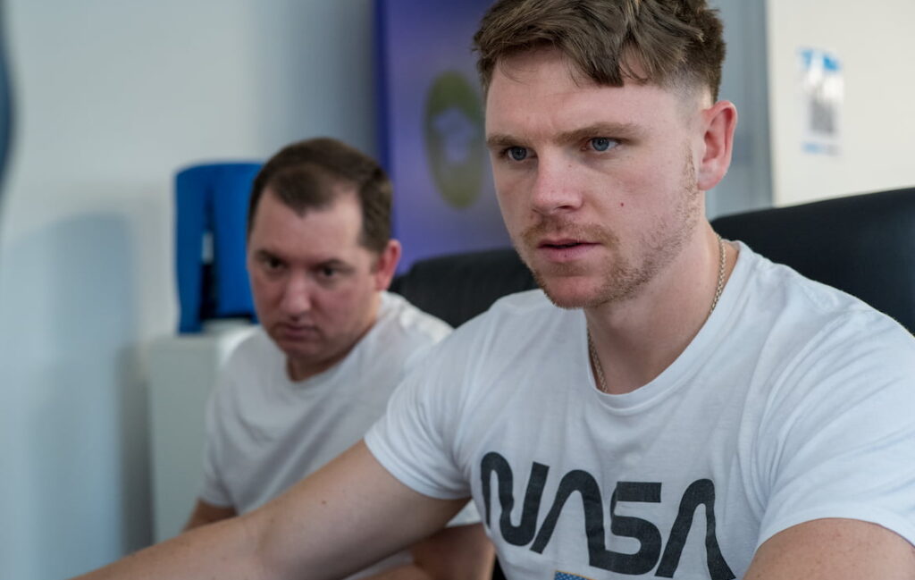 two people looking intensively at a computer screen out of shot