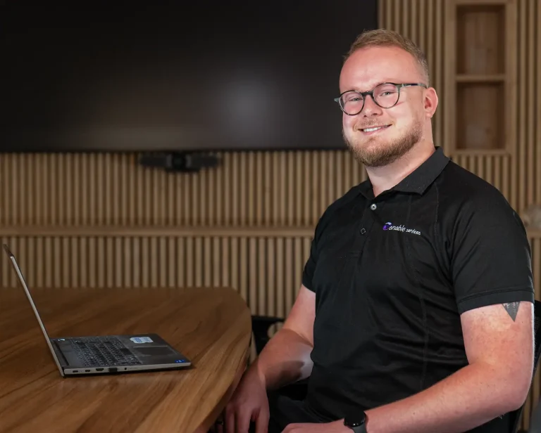 enable.services Tom Wilson sitting at a desk