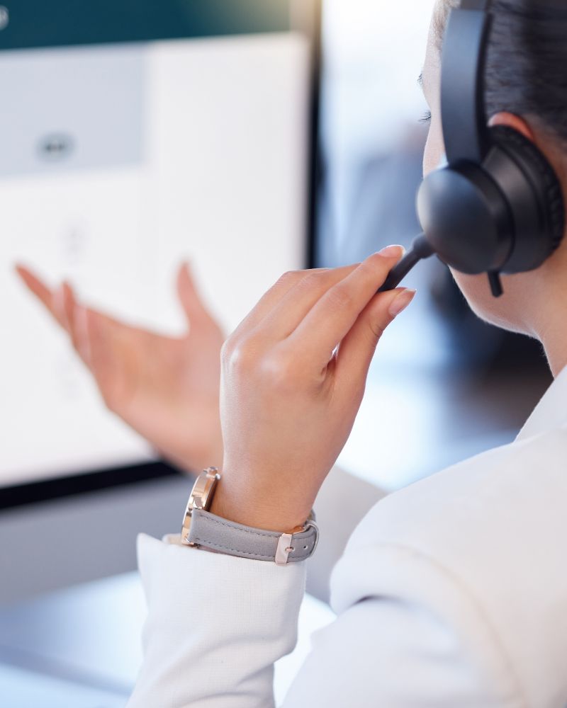 Woman wearing headset looking at a computer